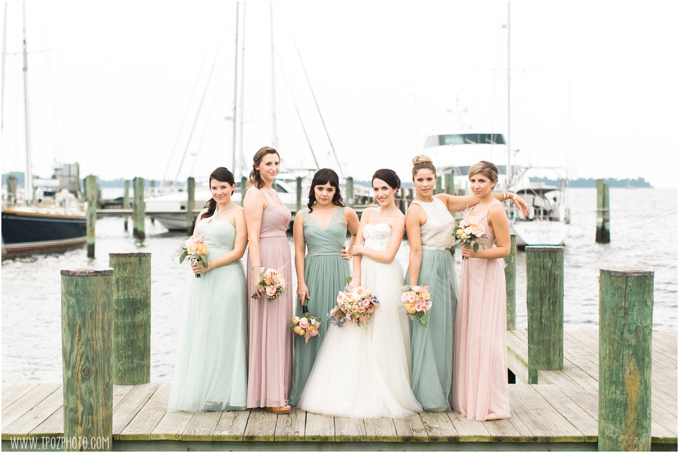 Bridesmaids in mint and blush dresses on a dock